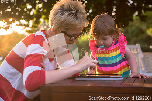 Image of mom and her little daughter using tablet computer