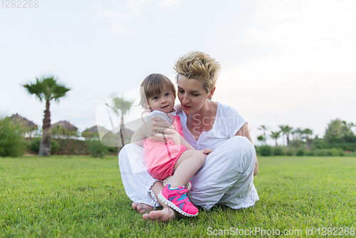 Image of mother and little daughter playing at backyard