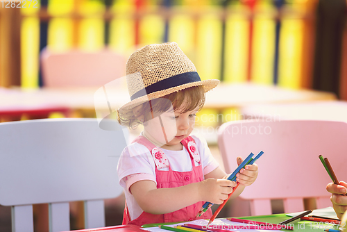 Image of little girl drawing a colorful pictures