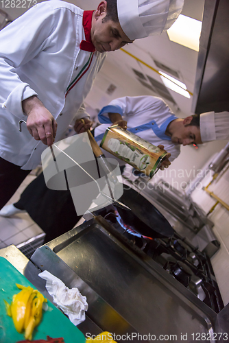 Image of chef preparing food, frying in wok pan