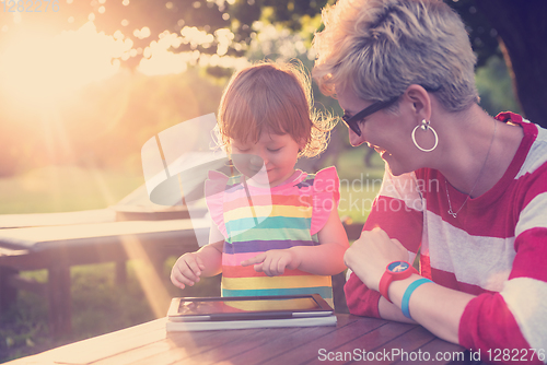 Image of mom and her little daughter using tablet computer