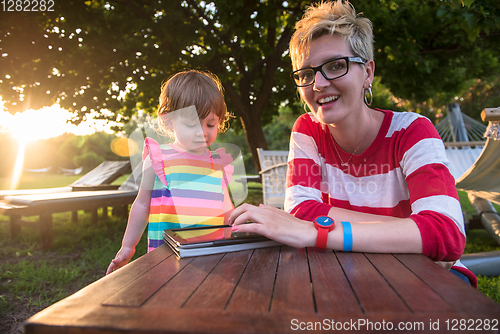 Image of mom and her little daughter using tablet computer