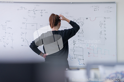 Image of female student writing on board in classroom