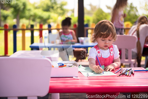 Image of little girl drawing a colorful pictures