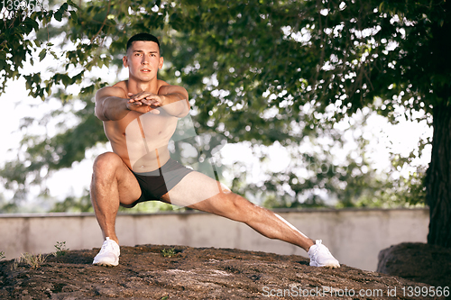 Image of A male athlete doing workout on the city\'s street or park