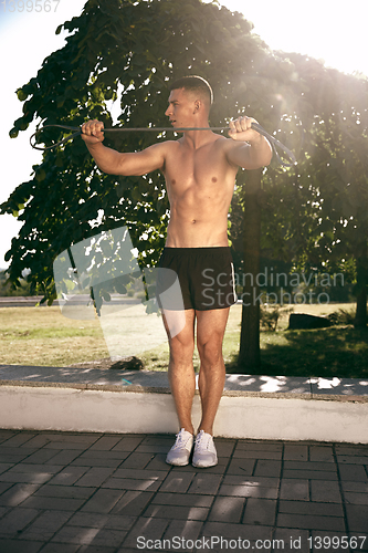 Image of A male athlete doing workout on the city\'s street or park
