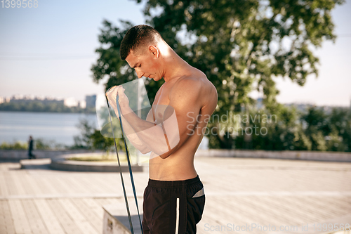 Image of A male athlete doing workout on the city\'s street or park