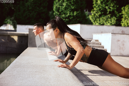 Image of A muscular athletes doing workout on the city\'s street or park