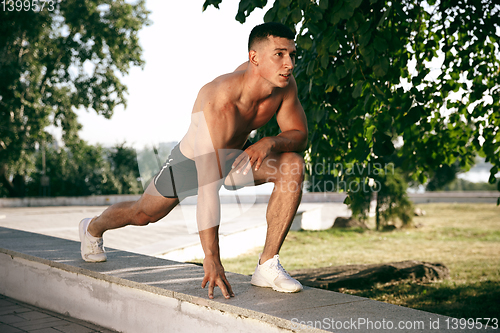 Image of A male athlete doing workout on the city\'s street or park