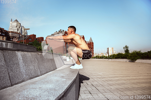 Image of A male athlete doing workout on the city\'s street or park
