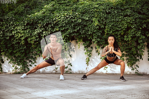 Image of A muscular athletes doing workout on the city\'s street or park