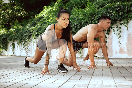 Image of A muscular athletes doing workout on the city\'s street or park