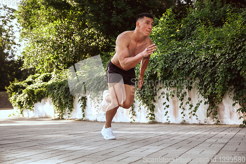 Image of A male athlete doing workout on the city\'s street or park