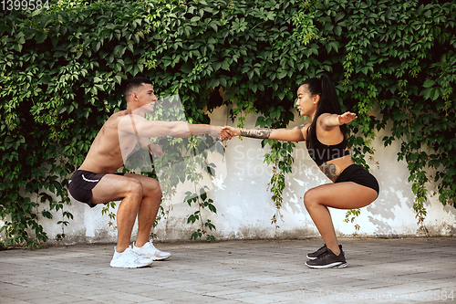 Image of A muscular athletes doing workout on the city\'s street or park