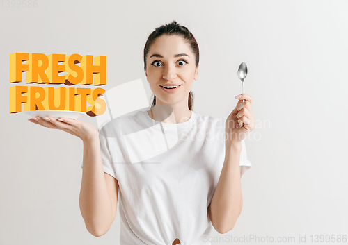 Image of Food concept. Model holding a plate with letters of Fresh fruits