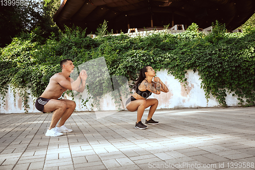 Image of A muscular athletes doing workout on the city\'s street or park