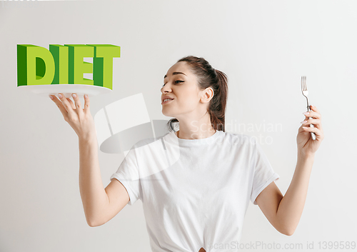 Image of Food concept. Model holding a plate with letters of Diet