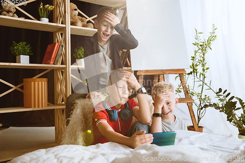 Image of Little boys using different gadgets at home