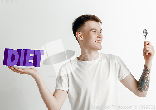 Image of Food concept. Model holding a plate with letters of Diet