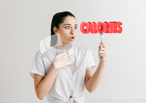 Image of Food concept. Model holding a plate with letters of Calories