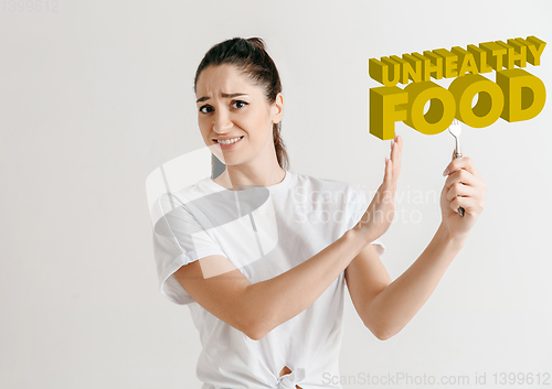 Image of Food concept. Model holding a plate with letters of Unhealthy Food