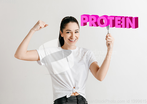 Image of Food concept. Model holding a plate with letters of Protein