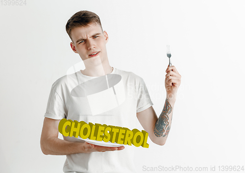 Image of Food concept. Model holding a plate with letters of Cholesterol