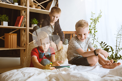 Image of Little boys using different gadgets at home