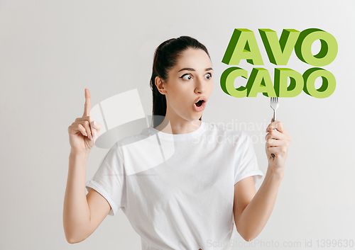 Image of Food concept. Model holding a plate with letters of Avocado