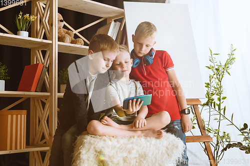 Image of Little boys using different gadgets at home