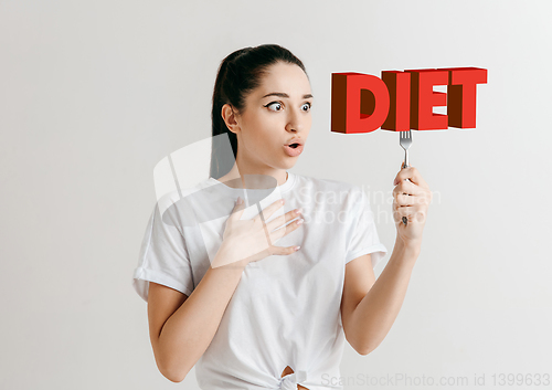 Image of Food concept. Model holding a plate with letters of Diet