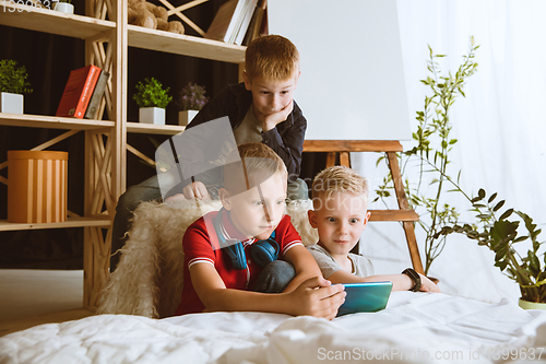 Image of Little boys using different gadgets at home