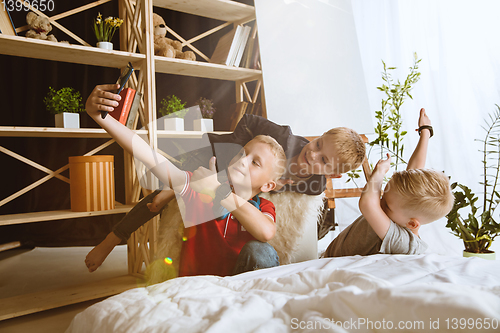 Image of Little boys using different gadgets at home