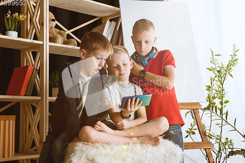 Image of Little boys using different gadgets at home