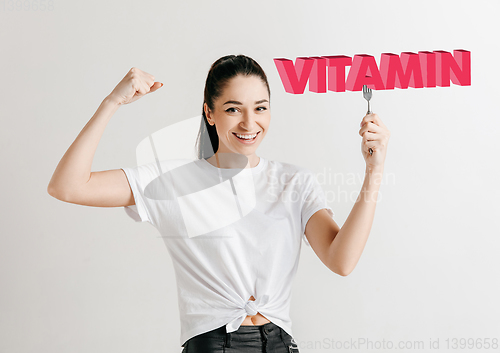 Image of Food concept. Model holding a plate with letters of Vitamin