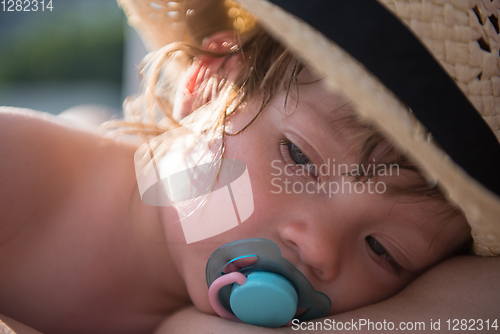 Image of mother and tired little daughter resting on sunbed