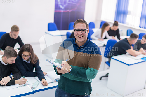 Image of male student with others writing notes