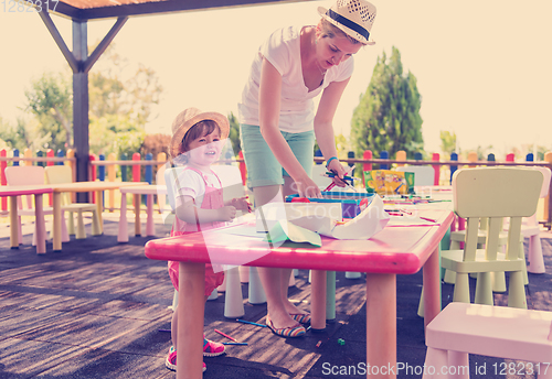 Image of mom and little daughter drawing a colorful pictures