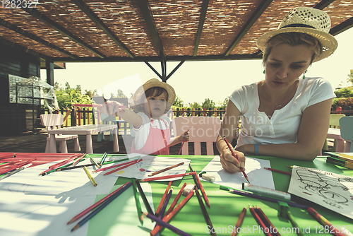 Image of mom and little daughter drawing a colorful pictures