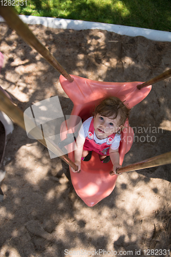 Image of little girl swinging  on a playground