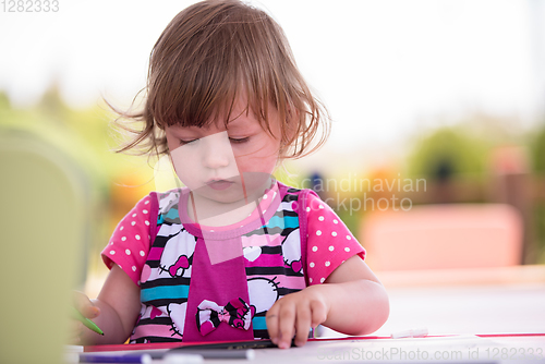 Image of little girl drawing a colorful pictures