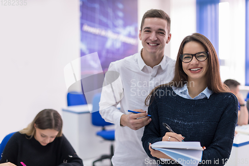 Image of young students writing notes