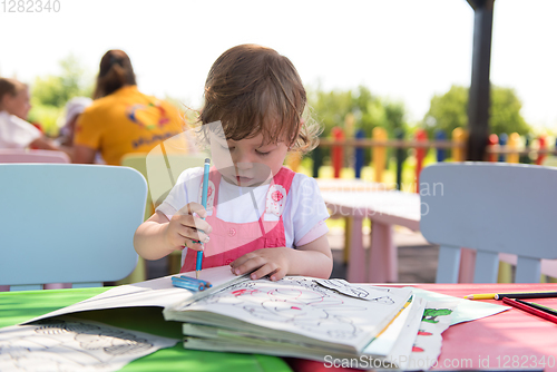 Image of little girl drawing a colorful pictures