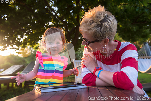 Image of mom and her little daughter using tablet computer