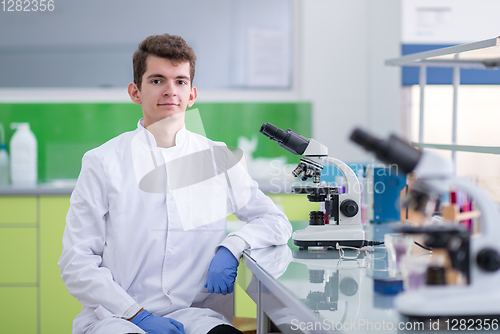 Image of student scientist looking through a microscope