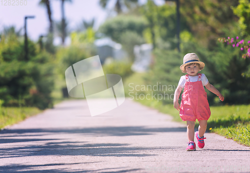 Image of little girl runing in the summer Park