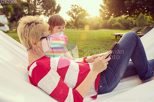 Image of mom and a little daughter relaxing in a hammock