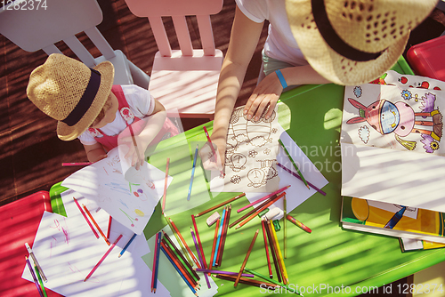 Image of mom and little daughter drawing a colorful pictures