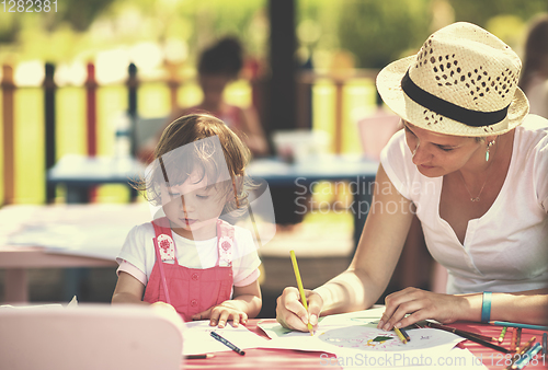 Image of mom and little daughter drawing a colorful pictures