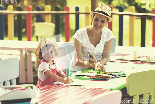 Image of mom and little daughter drawing a colorful pictures